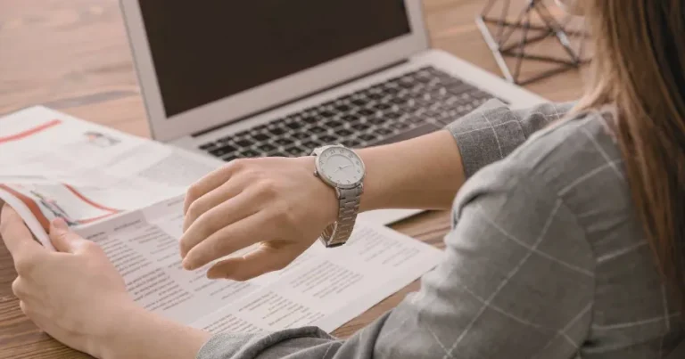 CFA candidate checking the time while studying, representing Parkinson's Law and time blocking techniques.
