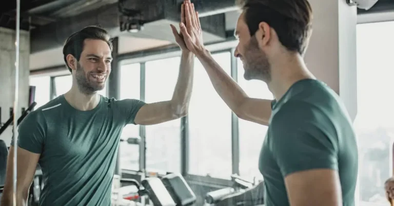 Man giving himself a high-five in the mirror, representing positive self-talk, mindset, and confidence