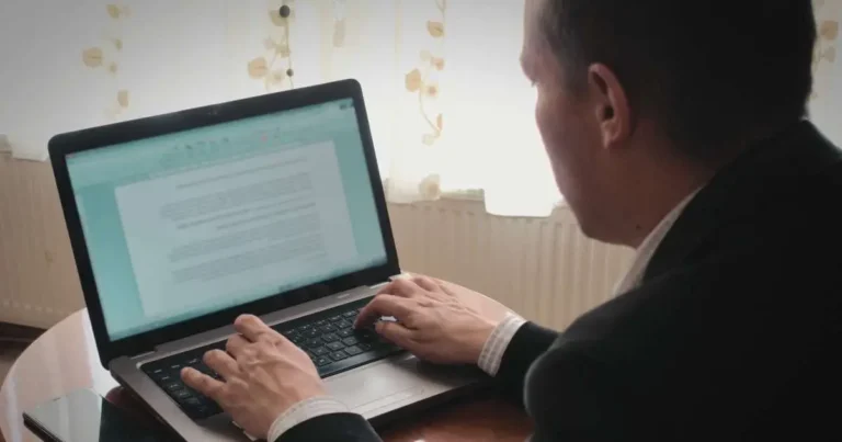 CFA Level 3 candidate typing an exam essay style question on a laptop