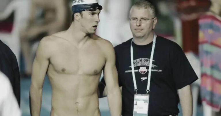 Michael Phelps and coach Bob Bowman at a swimming event, Phelps in swim gear with Bowman providing guidance and support.
