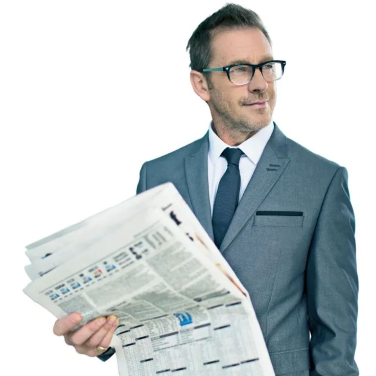 Man in grey suit reading a newspaper, staying updated on financial news