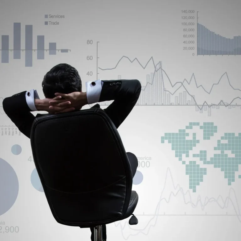 Man in chair viewing financial data charts on screen
